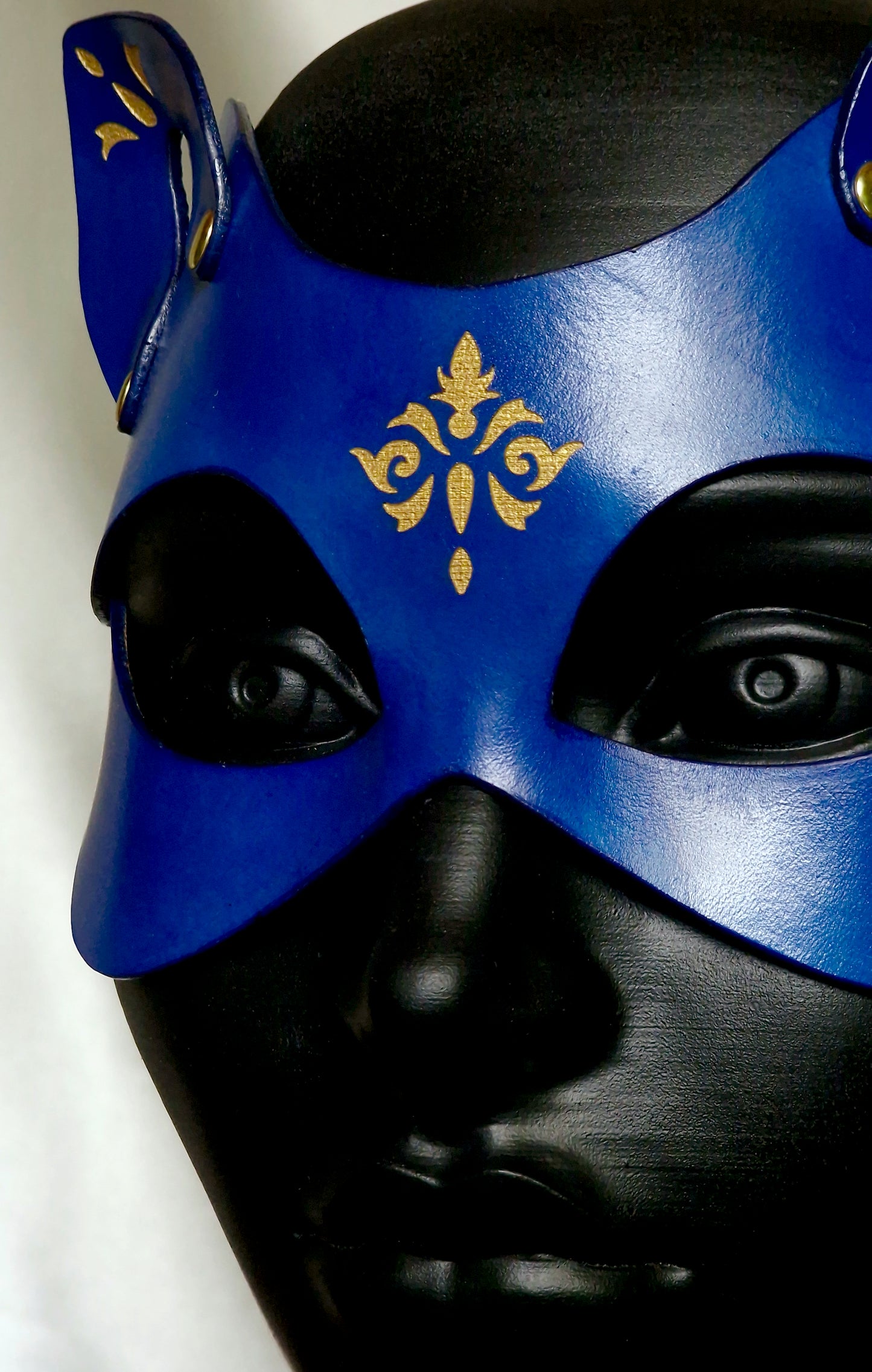 Close-up of engraved filigree on luxury feline mask.