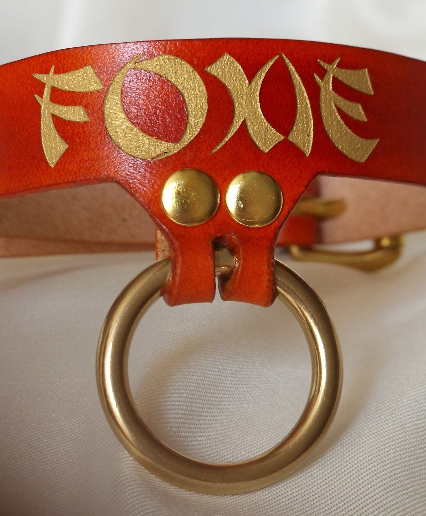 Close-up of engraved and hand-painted inscription on leather choker