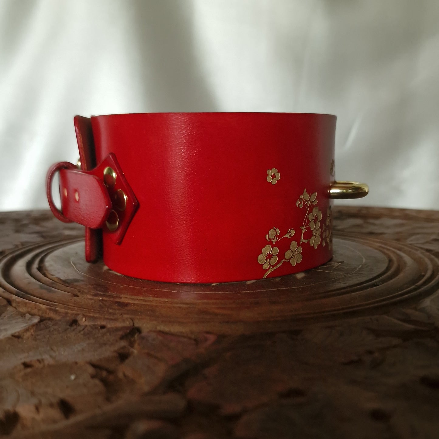 Side profile of engraved red leather collar with d-ring and micro gold or silver blossom ornament. Many colors available: green, blue, pink, purple, and more.