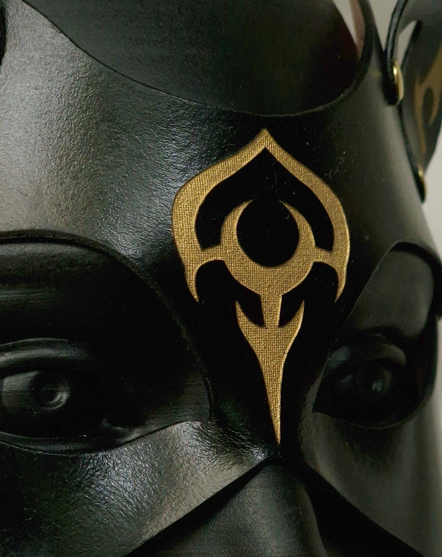 Macro of engraving on a lunar leather cat mask.
