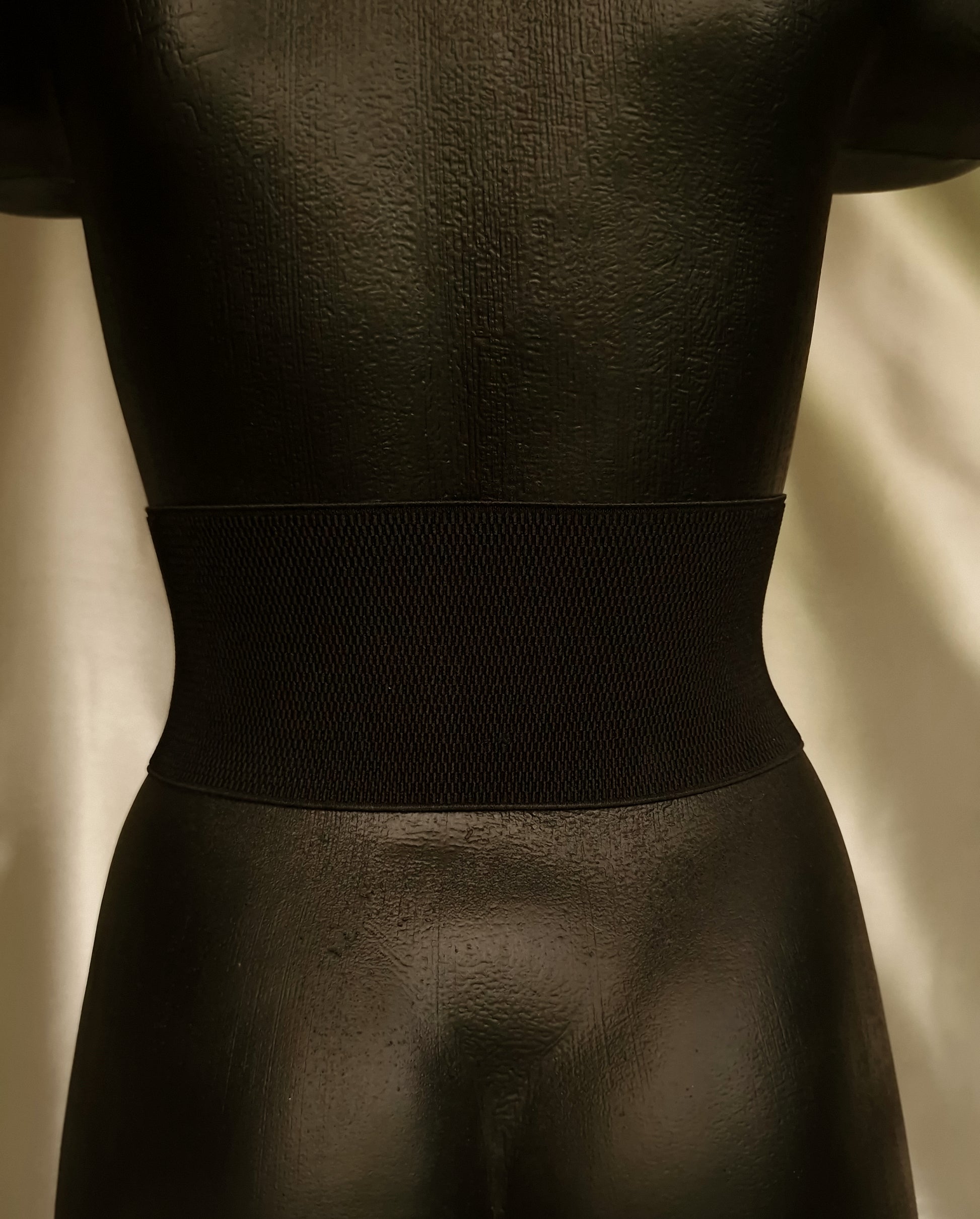 Back of dragon corset showing strong black elastic band and hand-stitched leather attachment