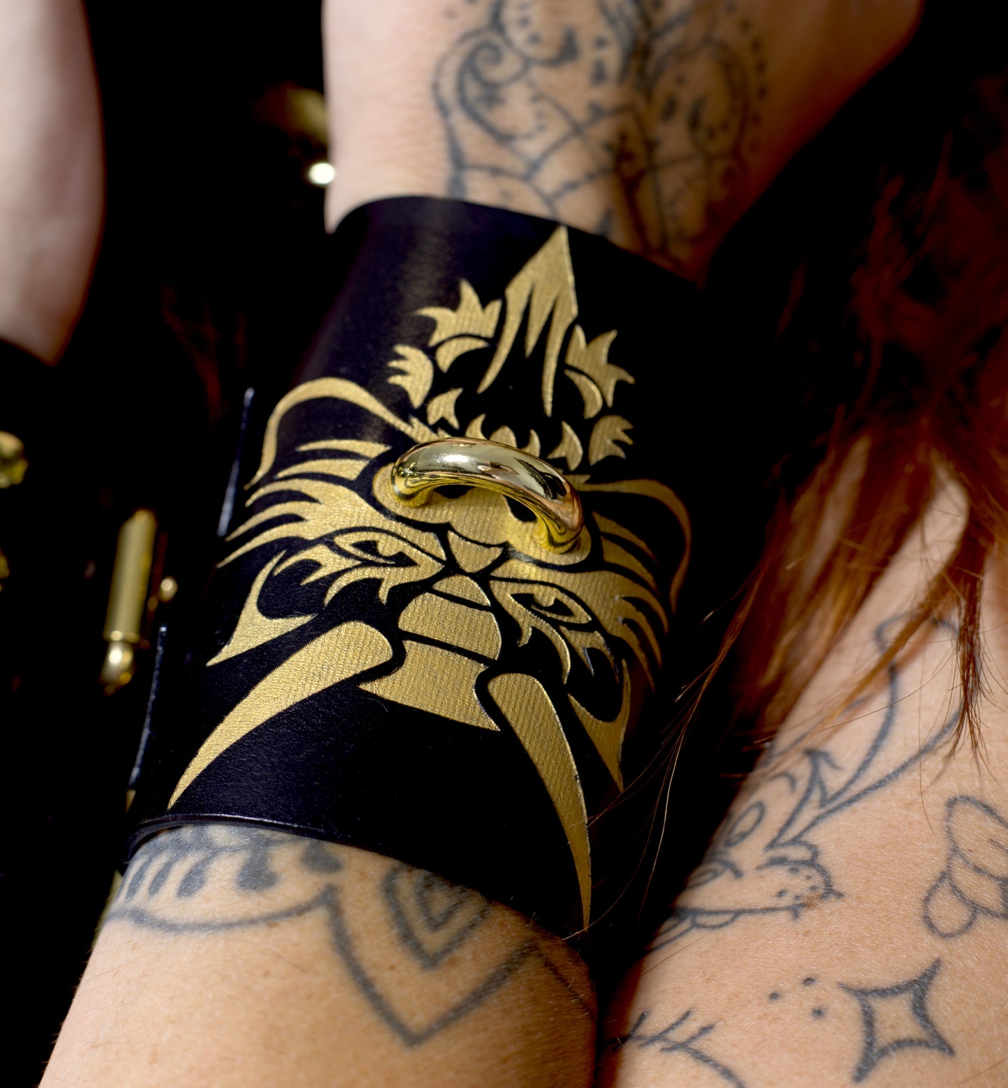 Close-up of dragon engraving on luxury leather wrist restraints.